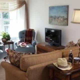 A cozy living room with comfortable seating, a TV, and tasteful decor.
