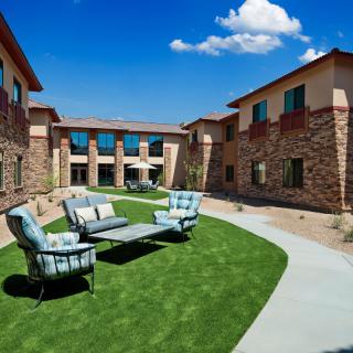 A landscaped courtyard with outdoor seating in a modern residential building complex.