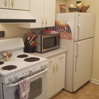 A compact kitchen with essential appliances and cabinets.