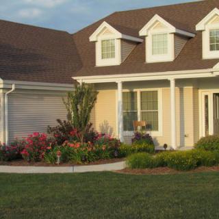 A suburban house with a well-maintained front yard and colorful flowers.