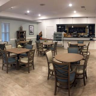 A modern dining area with neatly arranged tables and chairs.
