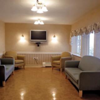 A cozy living room with couches, a television, and ample lighting.