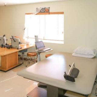 A clean and organized medical office with an examination table and equipment.