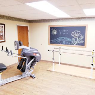 A dedicated fitness and rehabilitation space featuring exercise equipment and a chalkboard for motivational notes.
