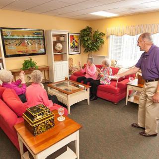 A group of seniors enjoying a video game together in a cozy living room setting.