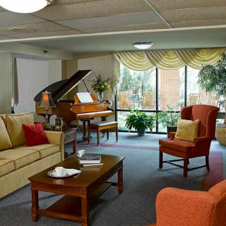 A cozy living room featuring a grand piano, comfortable seating, and inviting decor.