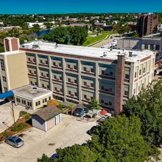 An aerial view of a multi-story hospital building with adjacent parking area.
