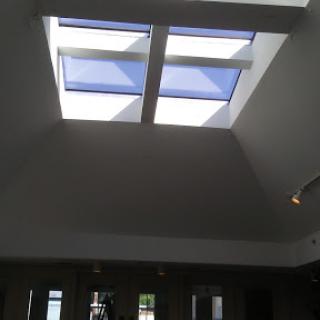 A view of a modern ceiling featuring skylights that allow natural light to illuminate the interior space.
