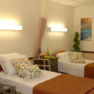 A hospital room with two beds and soft lighting.