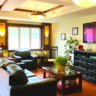 A well-decorated living room with comfortable seating and a television.