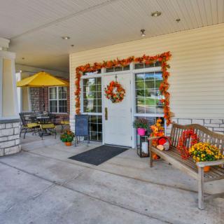 An inviting entrance decorated with autumn-themed accessories, including a wreath and seasonal plants.