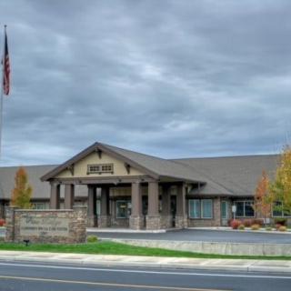 A school building under a cloudy sky with an American flag flying in front.