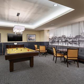 A modern game room featuring a billiards table and a cozy seating area.