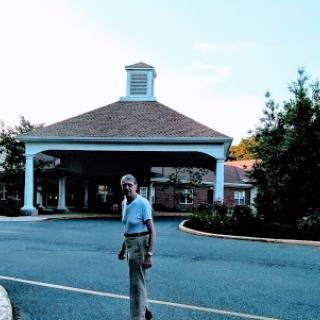 An elderly man walking towards a residential building.
