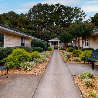 A well-maintained pathway with landscaping and benches between buildings.