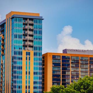 A view of contemporary high-rise buildings showcasing colorful glass facades against a blue sky.