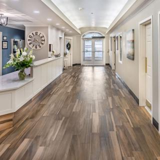 A modern and well-lit reception area with wood flooring and elegant interior decor.