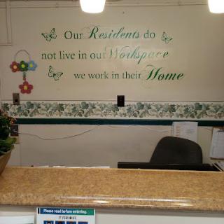 A welcoming reception area featuring a motivational quote emphasizing care and comfort for residents.