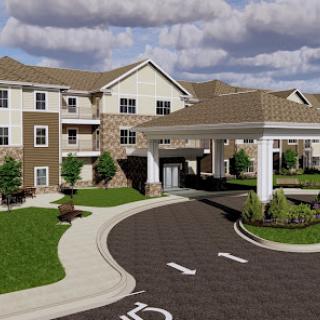 A modern residential building with a welcoming entrance, lush landscaping, and a clear sky.