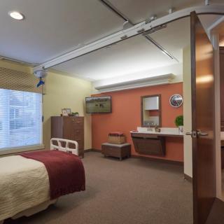 A well-furnished hospital room with a bed, medical equipment, and bathroom facilities.