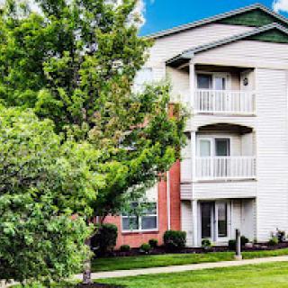 A charming residential apartment building surrounded by lush greenery.
