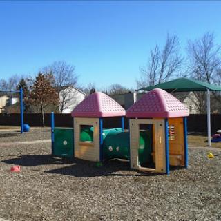 A vibrant playground featuring colorful playhouses and a tunnel, perfect for children's outdoor activities.