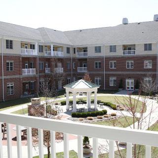 A serene courtyard view with a central gazebo surrounded by a multi-story residential building.