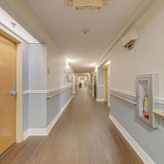 A brightly lit corridor with multiple doors and wall-mounted fixtures.