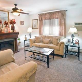 A cozy living room with comfortable sofas, a coffee table, and a fireplace.
