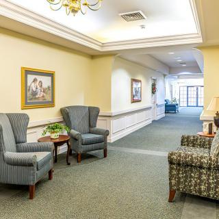 A cozy and well-decorated interior lobby with chairs, a sofa, and artwork on the walls.
