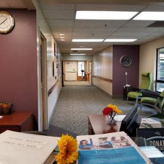 A view of a welcoming office reception area leading into a hallway.