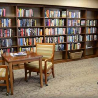 A cozy library reading area with shelves full of books and comfortable seating.