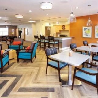 A modern and cozy lounge area with various seating arrangements and a warm color palette.