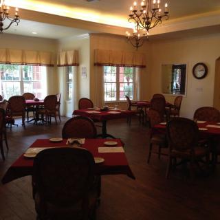 A cozy restaurant dining area with elegantly arranged tables and chandeliers.