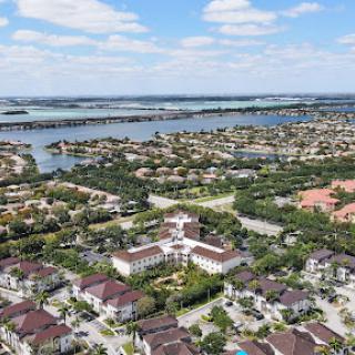 A stunning aerial view showcasing a mix of residential neighborhoods and waterways under a partly cloudy sky.