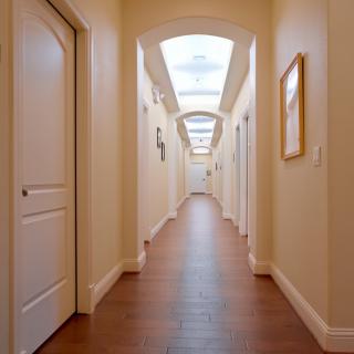 A well-lit hallway with several doors on each side.