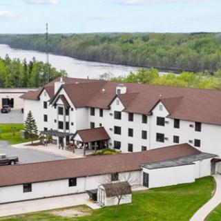 Aerial view of a riverside hotel surrounded by lush greenery.