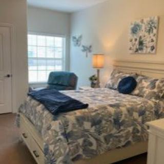 A cozy and elegantly decorated bedroom with a comfortable bed, stylish bedding, and warm lighting.
