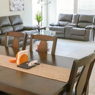 A cozy living and dining area featuring a wooden table with chairs and comfortable sofas.
