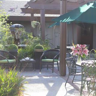 A serene outdoor patio adorned with comfortable seating and vibrant flowers, perfect for relaxation.