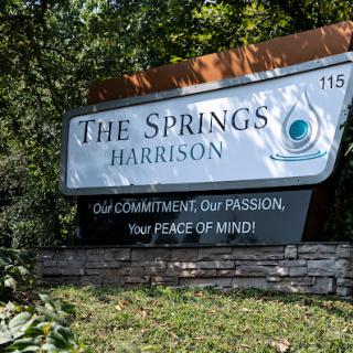 Signage for 'The Springs Harrison', emphasizing commitment and peace of mind.