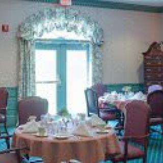 A cozy dining room with elegantly set tables and comfortable chairs.