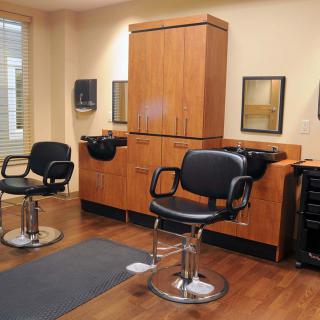 An interior view of a hair salon with styling chairs and mirrors.