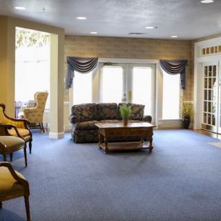 A cozy living room with furniture and large windows.