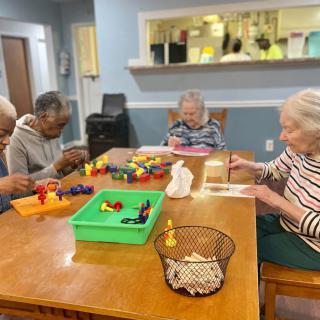 A group of elderly people engaging in activities at a care home.