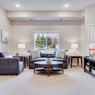 A cozy and well-lit living room featuring comfortable seating, a central coffee table, and stylish decor.