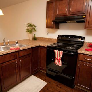 A cozy kitchen with wooden cabinets and a black stove.