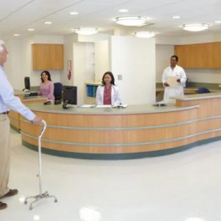 A patient approaches the hospital reception desk, where medical staff are ready to assist.