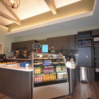 A modern cafe interior with a beverage display case and counter.