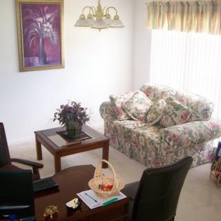 A cozy living room with a floral-patterned sofa and various decorative elements.